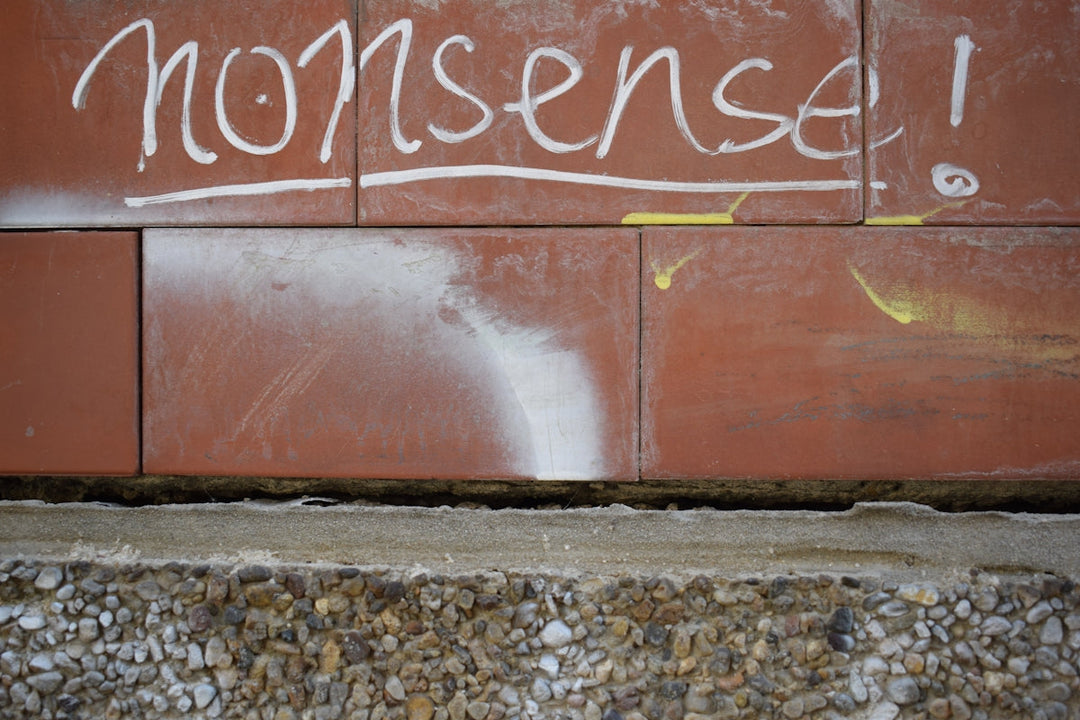 a red wall with graffiti written on it